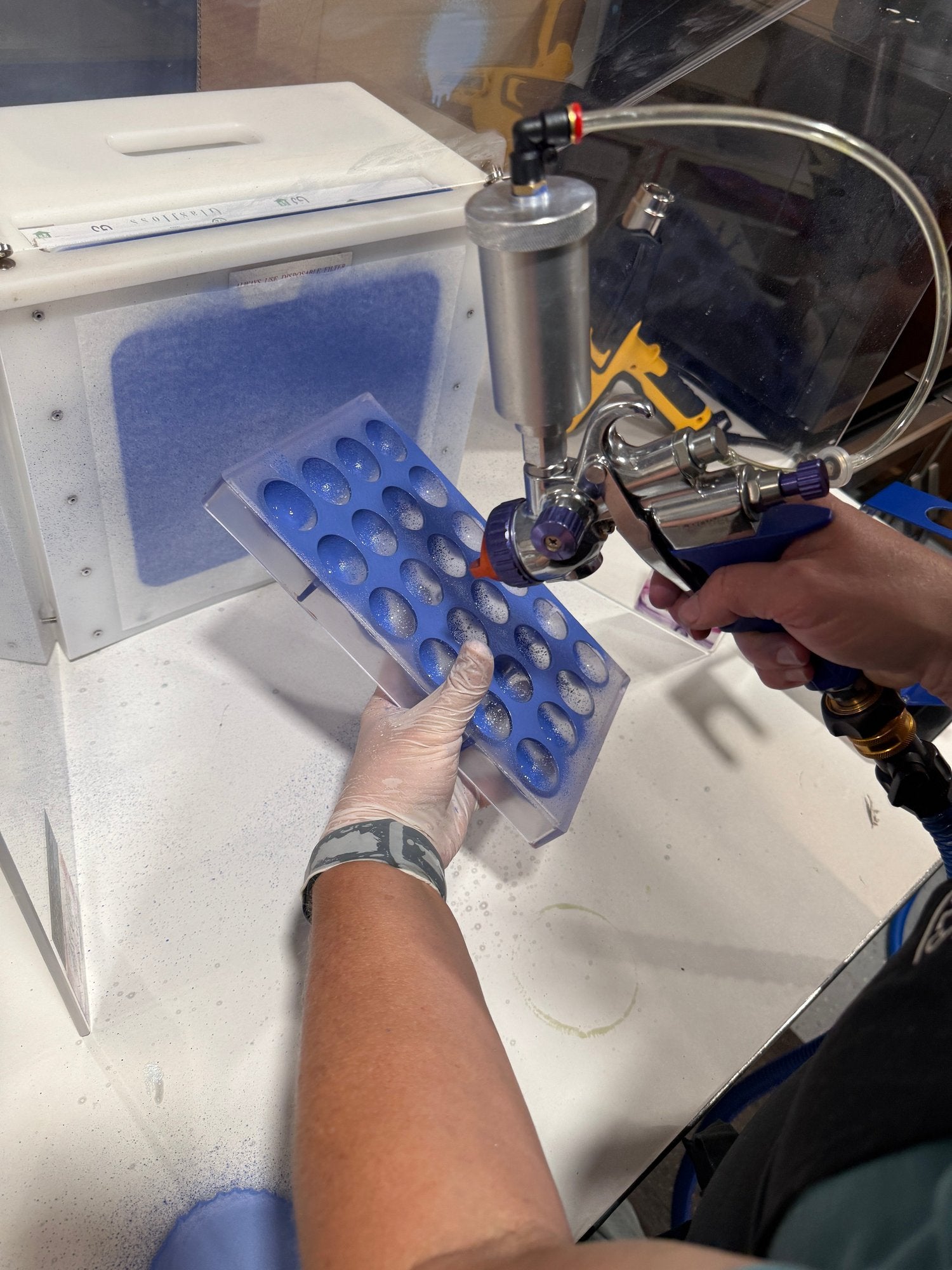 Fuji sprayer spraying a chocolate mold.
